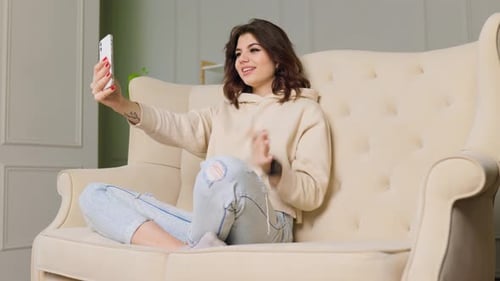 Smiling Woman Video Calling on Couch at Home