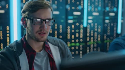 Man Works at Computer in Data Center