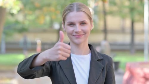 Woman Gives Thumbs Up in an Outdoor Setting
