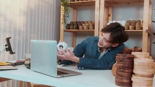 Young Adult Presents Vase on Laptop Video Call