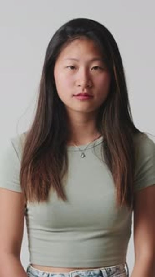 Young woman looking at camera isolated over white background in studio