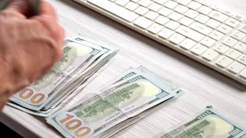 Counting Money at Desk by Computer Keyboard