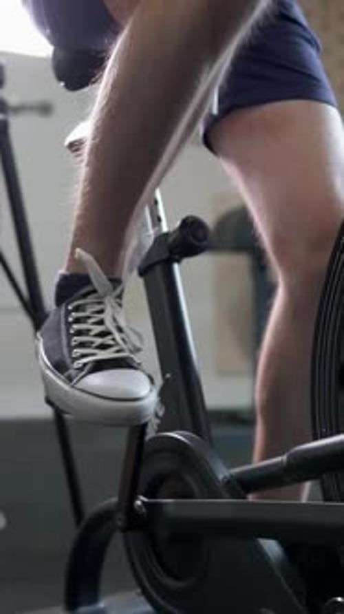 Athletic guy doing cardio workout on exercise bike. Motivation and strength.