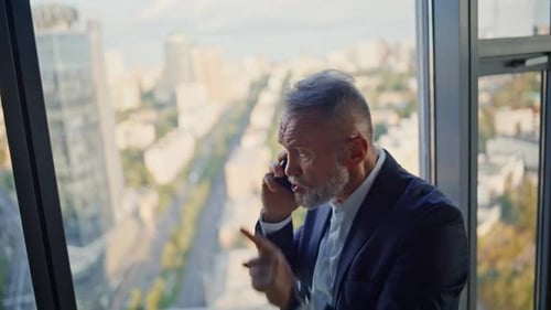Furious Senior Man Calling Smartphone By Window Highrise Building Closeup
