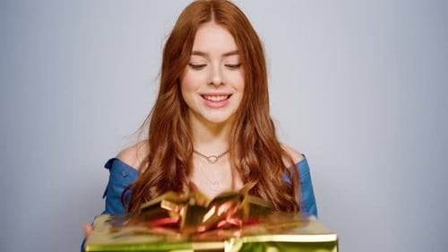 Excited Woman Shaking Gift Box Portrait