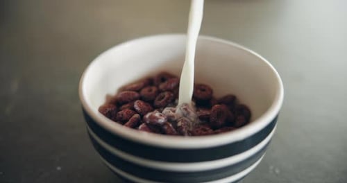 Pouring Milk into Cereal in a Bowl