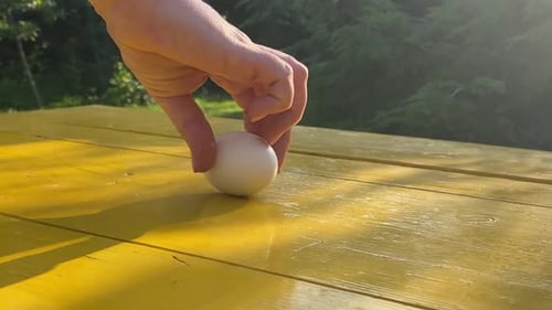 Rotating White Egg on Yellow Table Outdoors