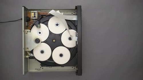 Hand Replaces Blank CD in Open Topped Five Disc Player, Top Down