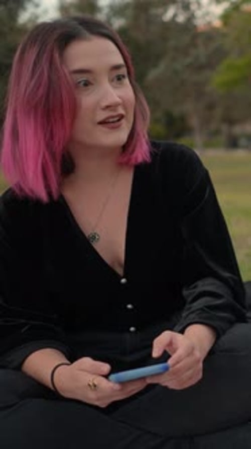 Woman with Pink Hair Using Smartphone in Park