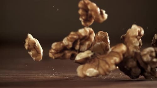 Walnuts Falling in Slow Motion on Wooden Surface