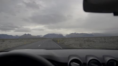 Slow motion POV shot of a car driving along a highway in rural Iceland