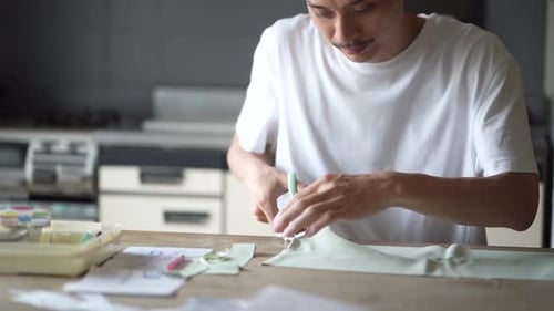 Adult Cutting Fabric with Scissors in Bright Workspace