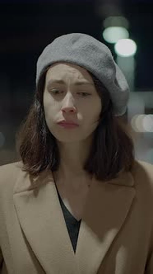 Woman Talking on Phone in City at Night