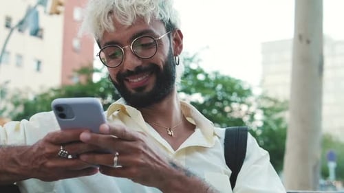 Smiling Person Using Smartphone in the City