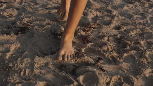 Bare Feet Walking on a Sandy Beach