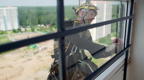 Steeplejacking. Professioneller Seilzugangstechniker arbeitet außerhalb des Gebäudes
