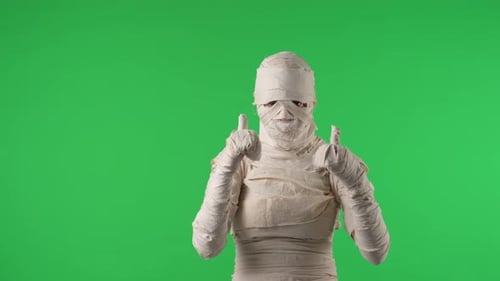 Vidéo à clé chromatique isolée sur écran vert capturant une momie donnant un pouce levé en secouant des bras, encourageant