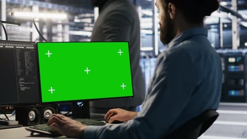 Data Center Technician Doing Software Updates Using Green Screen Mockup Computer
