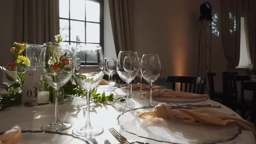 Empty Glasses Standing on Served Festive Table Opposite Sun in Window