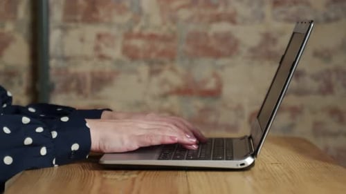 Closeup of Female Hands Using a Laptop in the Office Female Hands Typing on a Laptop Keyboard in the
