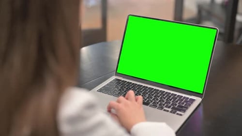Woman Using Laptop with Green Screen