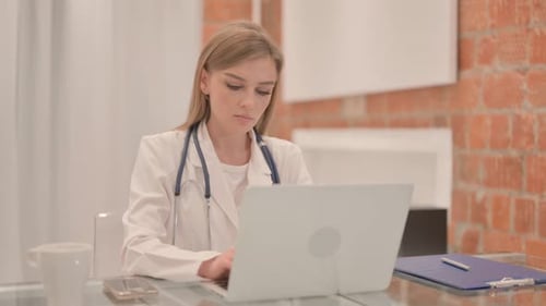 Female Doctor Working on Laptop in Clinic