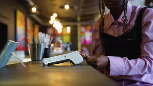 Woman Making Contactless Payment with Card at Restaurant Counter