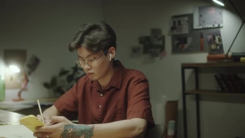 Asian Designer Using Phone and Drawing