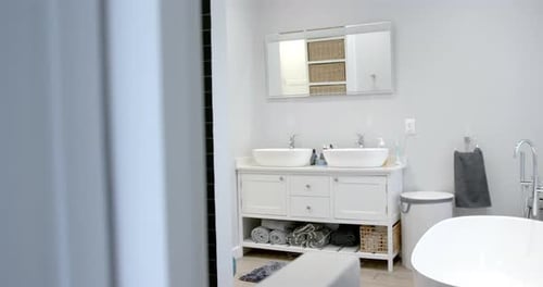 General view of bathroom with bathtub at home, mirror and washbasin, slow motion