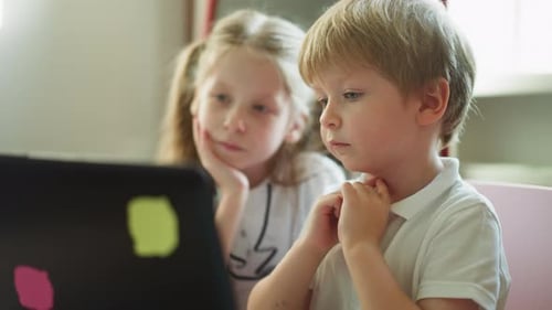 Children Using Laptop Computer Together at Home