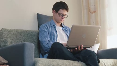 Young Adult Works on Laptop at Home