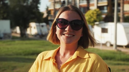Smiling Young Adult in Sunglasses and Yellow Shirt