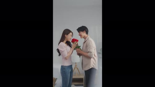 Man Gives Roses to Woman Indoors in Home