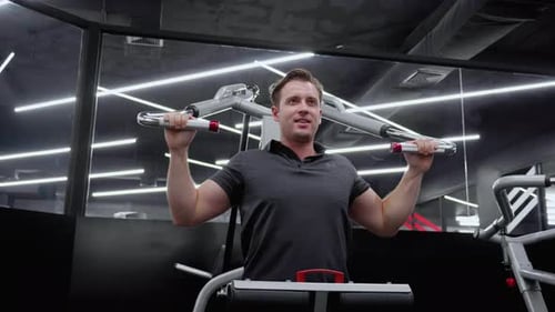 Young caucasian man workout with strength training and determination with fitness gym machines.