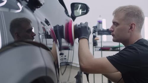 Man Polishing Car with Electric Polisher