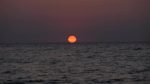 Sunset Over Ocean with Fiery Red Sun