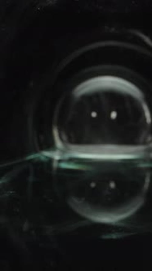 Macro video of a glass bottle. Dolly slider inside a water bottle close-up. Vertical video.