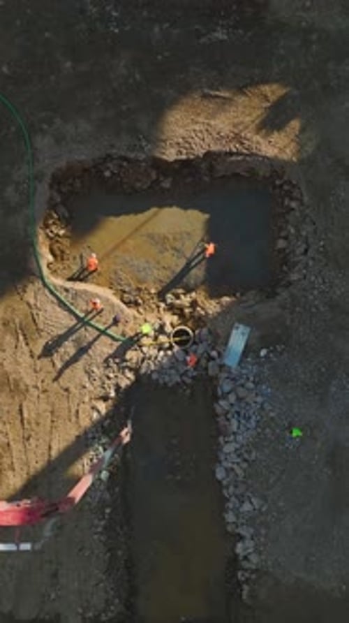 Vídeo vertical: trabajadores y maquinaria trabajando juntos para preparar los cimientos del edificio