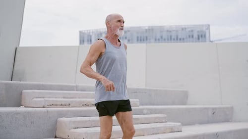 Senior Man Exercising on Concrete Steps in City