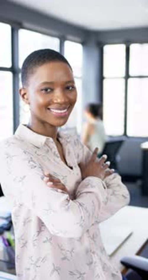 Vertical video of smiling african american businesswoman in office, slow motion, copy space
