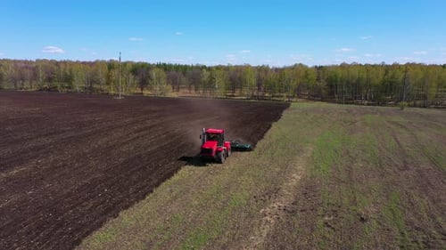 Red Tractor Working at Field