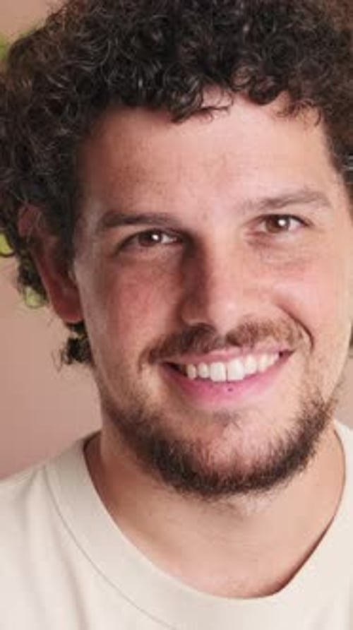 Close-up of guy standing in cozy living room looking at the camera with smile