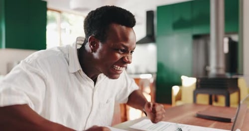 Man Celebrates Success While Working on Laptop