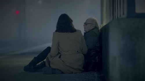 Woman and Senior Man Sitting on a Street