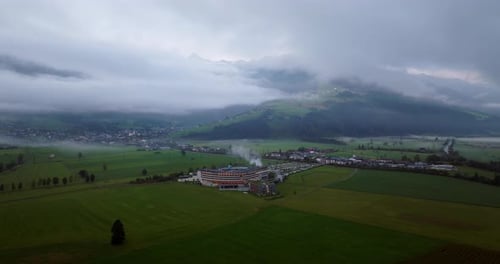Green Townscape Against Misty Peaks