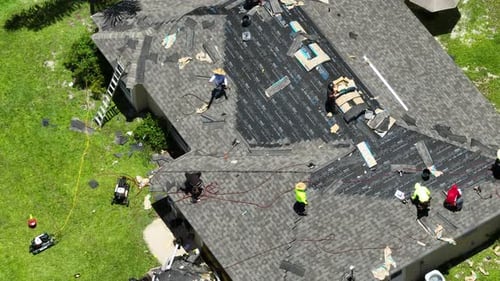 Workers Laying Asphalt Shingles on New House Rooftop Roof Finishing Works on Florida Home Real