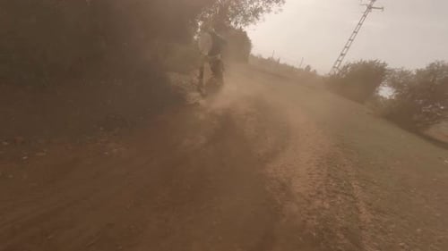 Dynamic FPV drone follows off-road moto rider on deep sand track