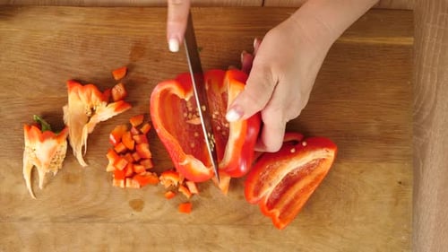 Woman Dices Red Bell Pepper on Cutting Board