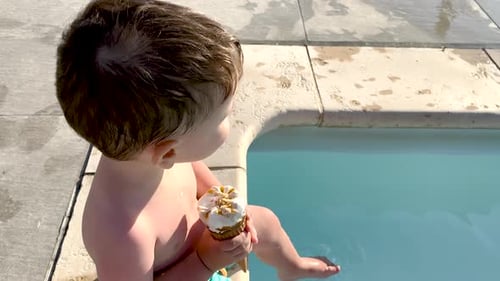 adorable kids siblings brothers on pool edge eating cone ice cream,legs feet playing into water wave