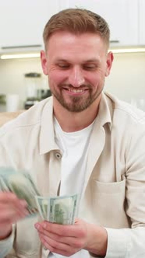 Young Man Counts Cash Dollars Smiles Happy with Savings Plans Dream Purchase Investment Bonus Salary